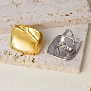 Macro detail of 304 stainless steel square rings with textured lava surface on stone