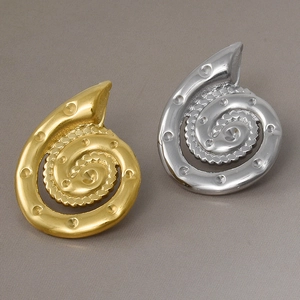 Vista macro di orecchini a spirale a forma di conchiglia con goffratura a punti dorata