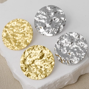 Detailed view of round hammered texture stud earrings in gold and silver finish