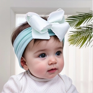 Close-up of baby wearing a mint green soft nylon elastic headband with white bow
