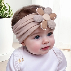 Détail d'un bandeau bébé avec fleur en tissu tricolore et large bande souple élastique