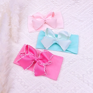 Detailed shot of three soft elastic nylon baby headbands with large scalloped lace bows