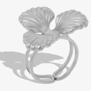 Close-up of a silver clover-shaped ring with textured petals and a double-layered open band