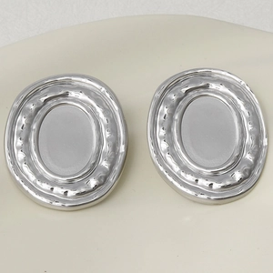 Macro shot of oval 304 stainless steel earrings with textured and polished silver finish
