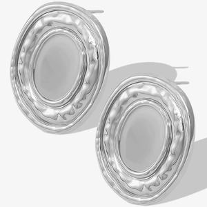 Detailed close-up of oval silver stud earrings with hammered edges and smooth mirror finish