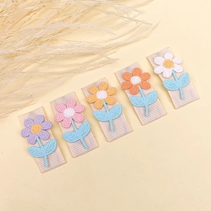 Detail eines 5er-Sets bestickter Blumen-Haarspangen mit bunten Stricktexturen