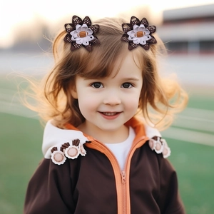 Détail de pinces à cheveux pour enfants avec rubans à pois et motif de football américain