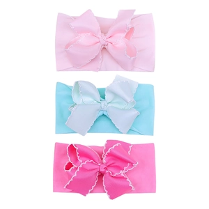Three-piece set of baby nylon headbands with large scalloped edge bows in pink and green
