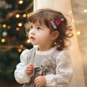 Sparkly red sequin Christmas hat hair clip for kids worn by a model in a cozy festive setting