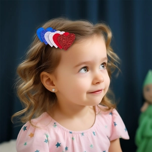 Close-up of glittery red, white, and blue heart hair clips on a child's side hair