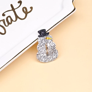 Detail of glitter snowman hair clip with silver sequins and a black top hat for Christmas