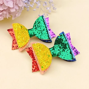Coppia di fermagli per capelli arcobaleno glitterati per bambine su sfondo beige
