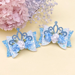 Close-up of glittery blue flower crown hair clips for kids with satin and sequin details
