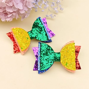 Dettaglio dei fermagli per capelli glitter arcobaleno con paillettes colorate per bambine