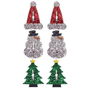 Macro detail of glitter Christmas tree, snowman, and Santa hat hair clips for kids