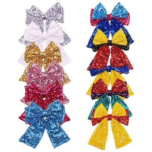 Detail shot of assorted sequined bow hair clips in vibrant colors with sparkling texture