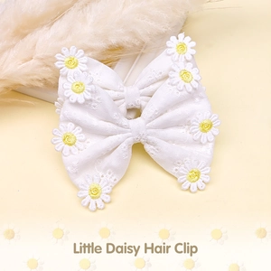 Gros plan détaillé de pinces à cheveux à nœud en tissu blanc avec marguerites brodées