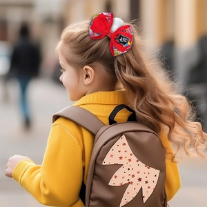 Détail d'un nœud pour cheveux écolière avec tableau ABC et crayons sur une fillette