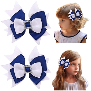 Detail view of navy and white bow hair clip with rhinestone center and child wearing it