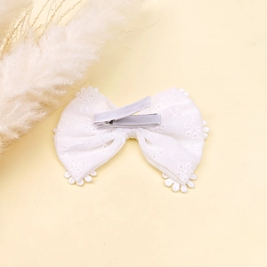 Détail de la pince à cheveux nœud en dentelle blanche avec clip crocodile gainé de tissu