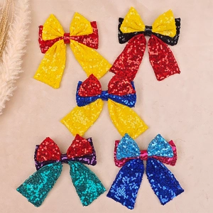 Flat lay of five sequined bow hair clips in various vibrant fairy tale character colors