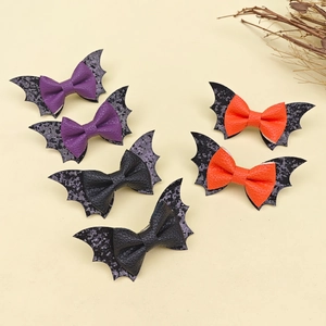 Vue à plat de barrettes chauve-souris violettes, orange et noires à paillettes