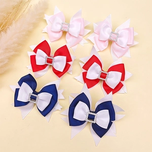 Detail of multi-layered grosgrain bow hair clips with sparkling rhinestone buckles