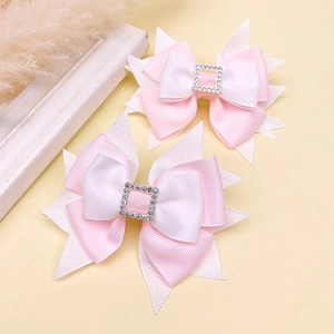 Detail of pink and white layered ribbon hair clips with rhinestone square buckle
