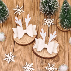 Détail de nœuds à cheveux bois de renne crème sur un décor de Noël en bois