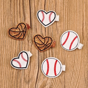 Close-up of glitter basketball and baseball hair clips with sequins and embroidery