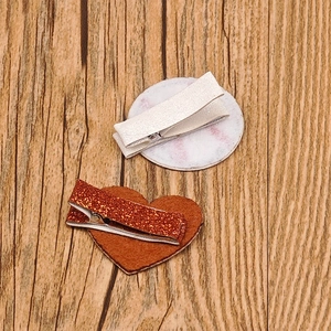 Detailed view of sequined football-themed hair clips with heart and round base pads