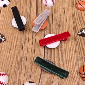 Detalle de pinzas para el cabello de terciopelo con balones sobre fondo de madera