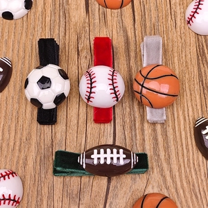 Detalle de pinzas para el cabello deportivas con motivos de fútbol, béisbol y básquet