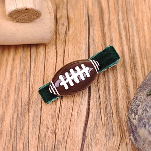 Detalle de pinza para el pelo de fútbol americano con textura marrón y terciopelo verde