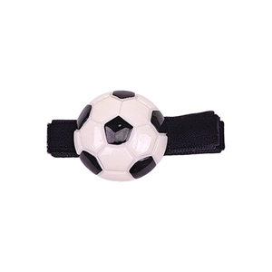 Detalle macro de un dije de fútbol clásico en una banda elástica negra para el pelo