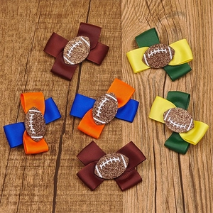 Détail de diverses pinces à cheveux avec nœud thème football américain sur fond de bois