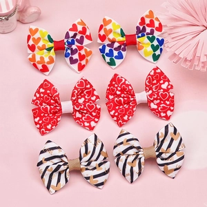 Dettaglio di fiocchi per capelli colorati con cuori e stampe LOVE a righe sottili