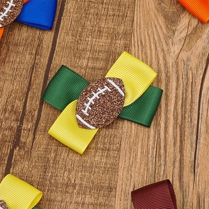 Detail einer grün-gelben Ripsbandschleife mit einem braunen Glitzer-Football-Symbol