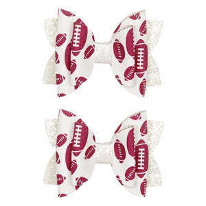 Detalle de dos lazos para el pelo con diseño de fútbol americano y purpurina blanca