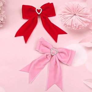 Détail de barrettes en velours rouge et rose avec strass en forme de cœur brillant
