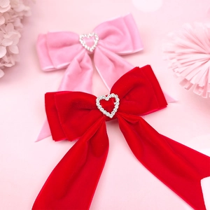 Détail de barrettes nœuds en velours avec strass en forme de cœur brillant pour filles