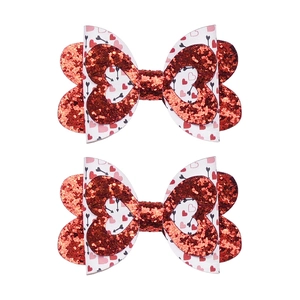 Détail de nœuds en paillettes rouges et tissu à motifs cœurs disposés verticalement