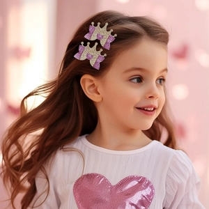 Close-up of a girl wearing glittery crown hair clips with pink and gold sequins