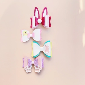 Detailed view of four handmade Easter hair clips with bunny ears, chicks and glitter finish