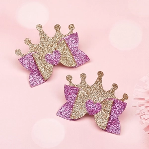 Close-up of pink and gold glitter crown hair clips with bow and heart detail for girls