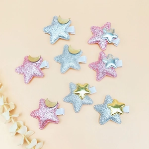 Eight cute glitter star hair clips for girls featuring moon and star decorations