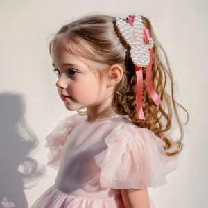 Detail of child hair claw with white pearls rabbit ears and long pink silk ribbons
