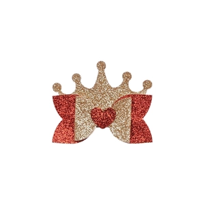 Close-up of glitter crown and red bow hair clip with heart detail for girls