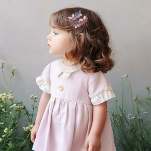 Dettaglio di una bambina con fermagli per capelli a farfalla glitterati sui capelli ricci