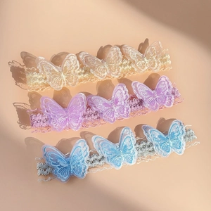 Close-up of three lace butterfly headbands in cream, lavender and light blue colors
